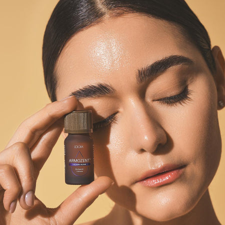 Huile essentielle ARMOZENT™ Lolûm posée sur fond naturel, produit calmant à base de mandarine, lavandin et ylang ylang