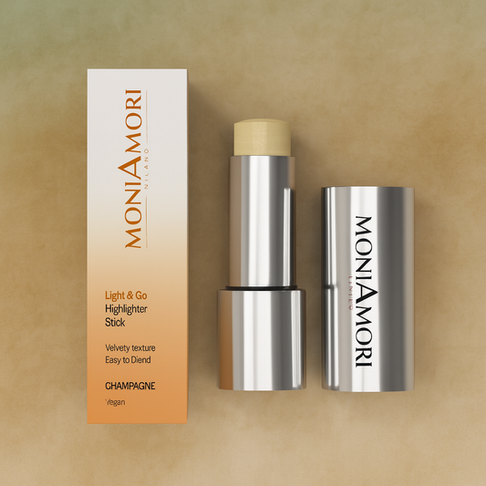 Stick highlighter MoniAmori teinte Champagne sur fond doré clair – éclat subtil et naturel.